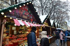 A woman with a child are photographed against the backdrop of a New Year's installation