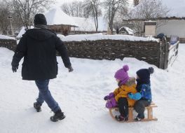 A man carries children on sleds