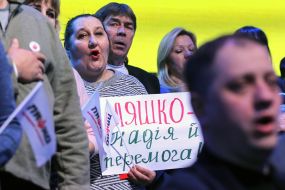 Участники съезда держат плакаты в поддержку Олега Ляшко
