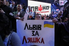 Участники съезда держат плакаты в поддержку Олега Ляшко