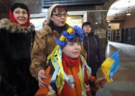 A girl in a wreath with a flag of Ukraine in her hands