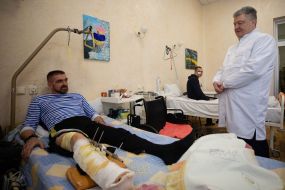 Петро Порошенко спілкується з пораненим військовослужбовцем