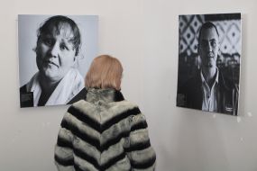 Visitor of the exhibition near photo portraits