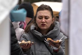 Девушка держит блины на бумажной тарелке