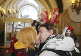 Молодые мужчина и женщина целуются в помещении станции фуникулера