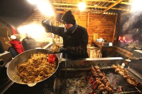 A man pours into a plate of pilaf