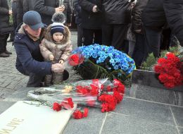 A man with a little girl lay flowers