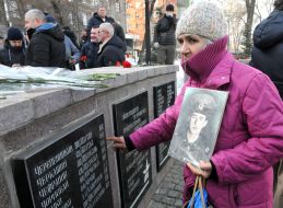 A man with a little girl lay flowers