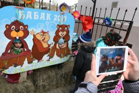 Children near a poster with painted marmots