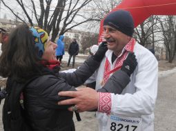 Женщина встречает с медалью участника пробега "Snow Run"