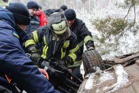 Rescuers try to unlock people from an inverted car