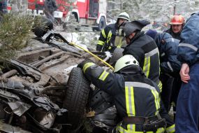 Rescuers try to unlock people from an inverted car