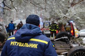 Rescuers try to unlock people from an inverted car