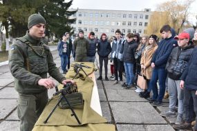 A military man demonstrates a machine gun to his disciples