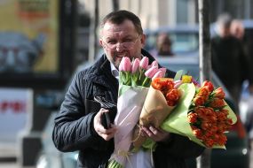 Прохожий с букетами тюльпанов