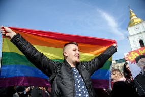 Молодой человек держит флаг ЛГБТ