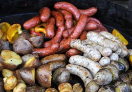 Baked potatoes and fried sausages on a pan