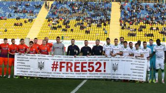 Players of FC "Karpaty" and FC "Mariupol" teams hold a banner in support of political prisoners