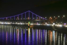 Подсвеченный фиолетовым цветом Парковый (пешеходный) мост через Днепр