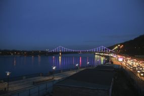 Подсвеченный фиолетовым цветом Парковый (пешеходный) мост через Днепр