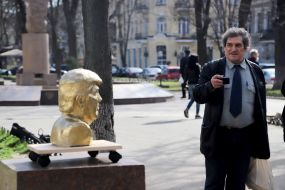A man photographs a monument to Donald Trump