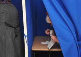 Жінка в кабінці для голосування