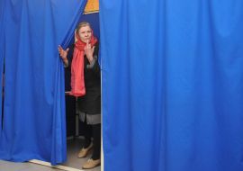Жінка в кабінці для голосування