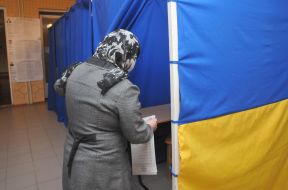 Жінка заходить в кабінку для голосування