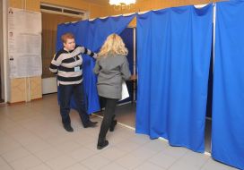 Жінка заходить в кабінку для голосування