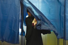 A priest comes out of the polling booth