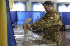 A serviceman puts a ballot in a ballot box