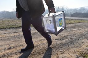 Представитель избирательной комиссии с переносной урной для голосования