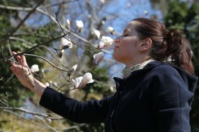 Девушка держит ветку цветущей магнолии