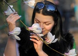 Девушка держит ветку магнолии