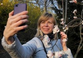 Девушка делает селфи на фоне магнолии