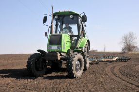 Трактор боронует почву 