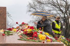 Protesters laying flowers at the monument to the Unknown Sailor