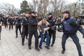 Police detain a man with St. George ribbon