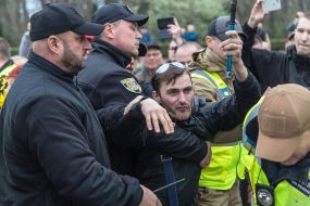 Police detain a man with St. George ribbon