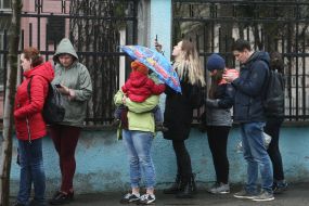 People stand in line to change voting places