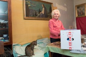 An elderly woman near a product package