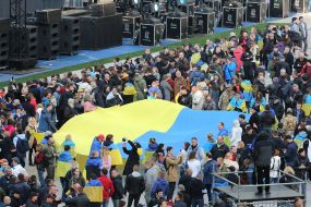 People hold the Ukrainian flag on the NSC "Olimpiyskiy" before the debate begins