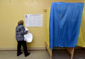 Пожилая женщина снимает предвыборные программы кандидатов