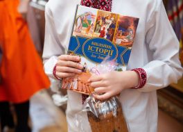 A boy holding a book and cake