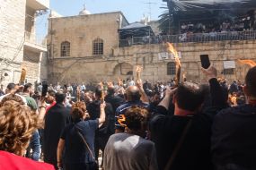 Believers hold candles lit from the Blessed Fire