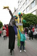 Actors of the theater "Resurrection" on stilts next to the girl