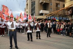 Men in Ukrainian national costumes play trembitas