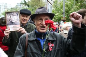 Участник акции "Бессмертный полк" с букетом гвоздик