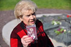 Жінка тримає в руках орденську книжку та орден 