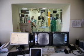 The operating chamber behind the glass and monitors control the patient's condition